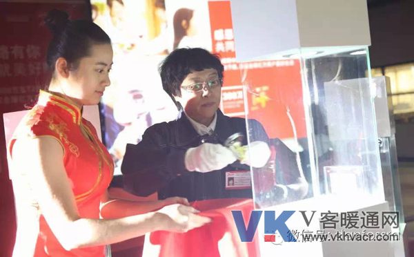 丹佛斯标准和产品认证经理的安金改女士身着工服将手中的一支金光闪闪的T2热力膨胀阀郑重地安放到展柜的中央